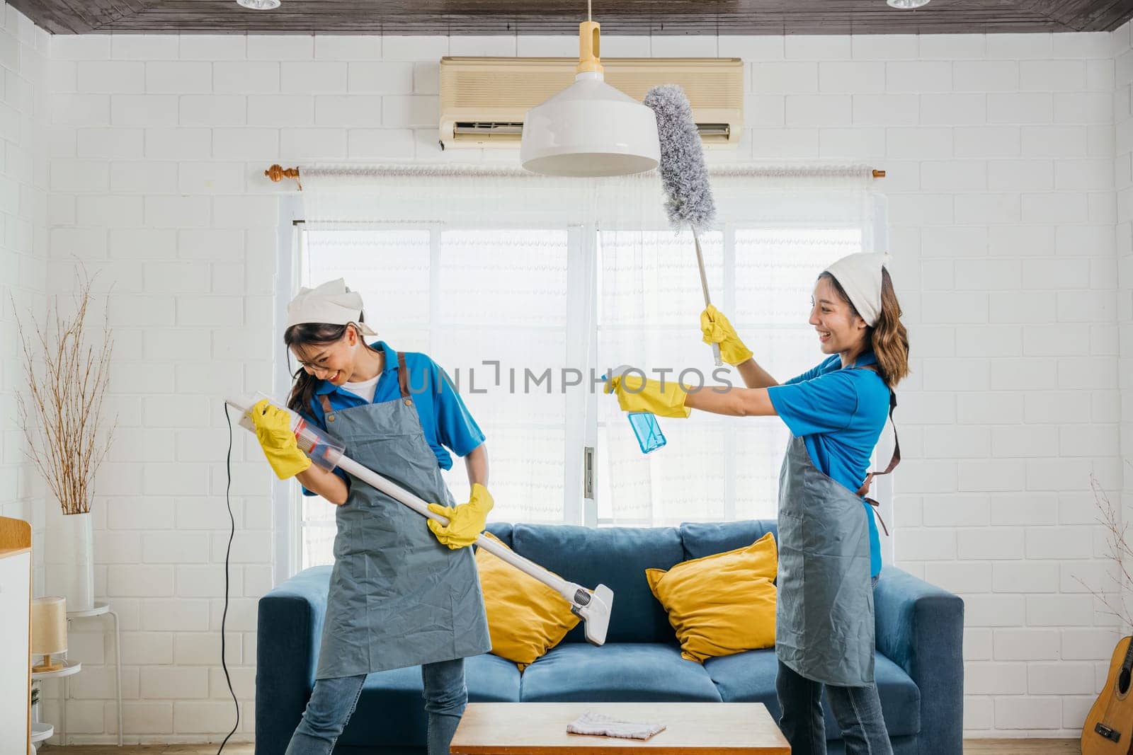 Maid cleaning melody, Asian woman enjoys vacuum guitar fun. Husband playful idea sparks singing dancing joyfully. Music-filled service adds excitement to household tasks. Cleaning is fun by Sorapop