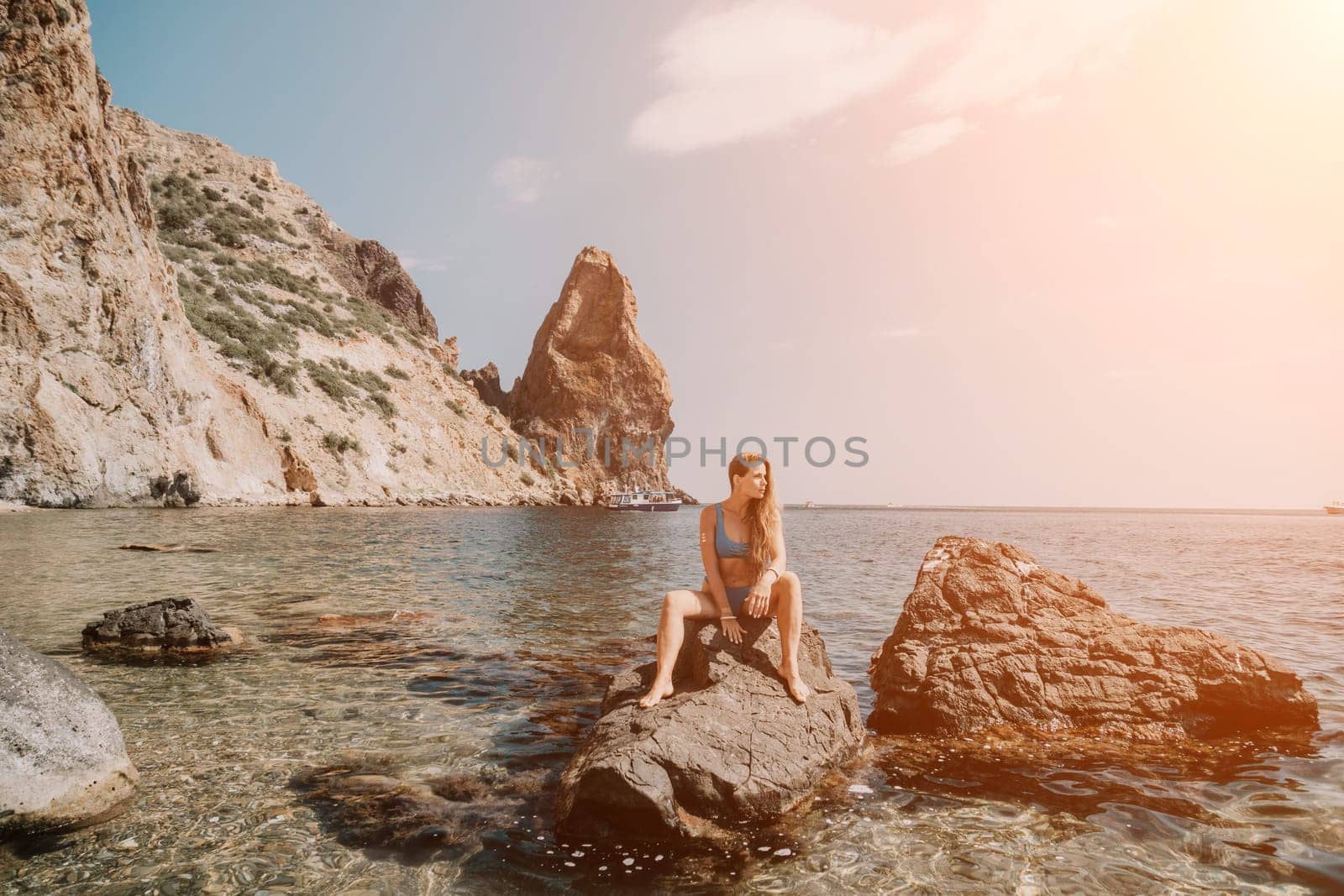 Woman summer travel sea. Happy tourist enjoy taking picture outdoors for memories. Woman traveler posing on the beach at sea surrounded by volcanic mountains, sharing travel adventure journey by panophotograph