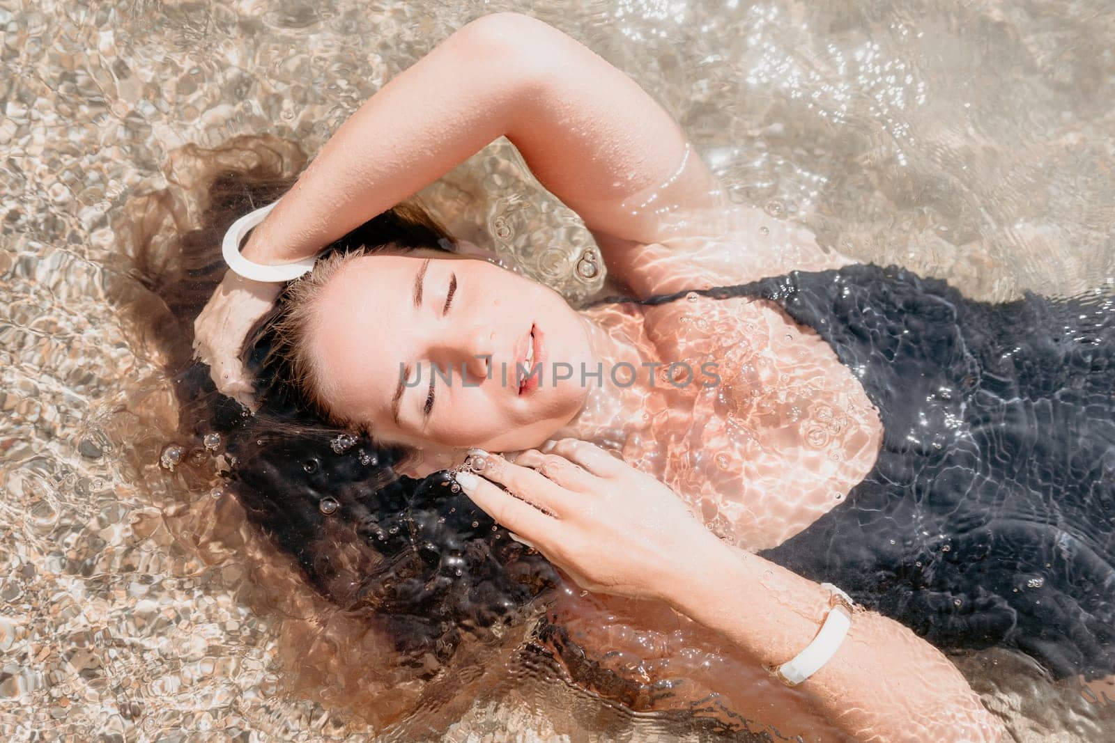 Woman summer travel sea. Happy tourist enjoy taking picture outdoors for memories. Woman traveler posing on the beach at sea surrounded by volcanic mountains, sharing travel adventure journey by panophotograph