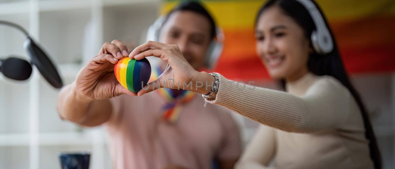 Young gay male and girl friend hands holding rainbow heart with smile face. LGBT, human rights and equality social by nateemee