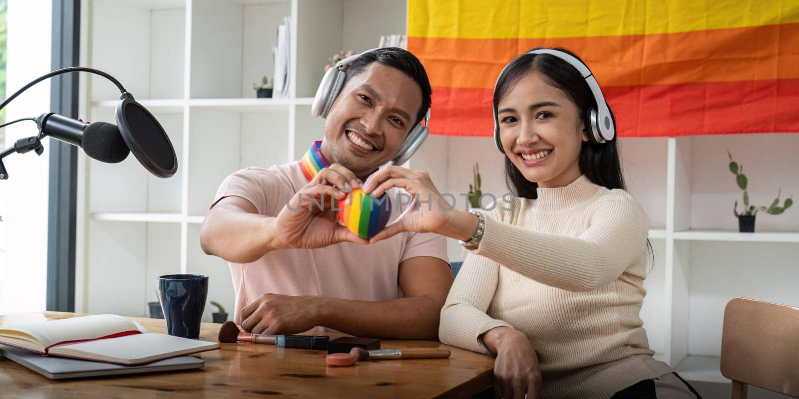 Asian gay radio host enjoy chatting while record an audio podcast with female friend.