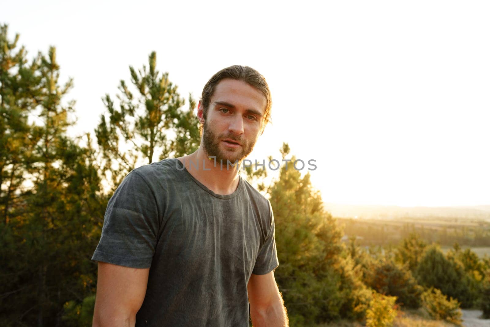 Casual man hiker outdoors in gray T-shirt outdoors portrait close up