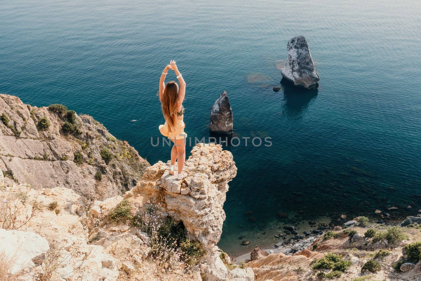 Woman travel sea. Happy tourist enjoy taking picture outdoors for memories. Woman traveler looks at the edge of the cliff on the sea bay of mountains, sharing travel adventure journey by panophotograph