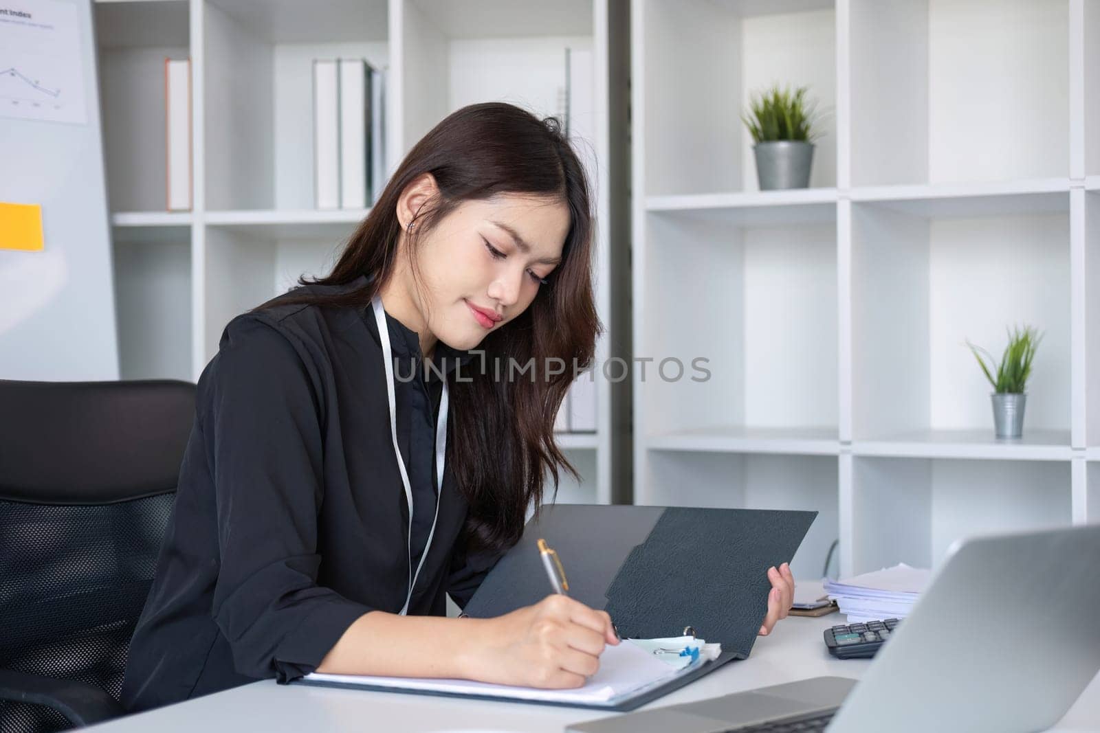 Business documents, business auditor Asian woman is reviewing legal documents, preparing documents or reports for analysis tax accountant documents agreement contract information in office at work.