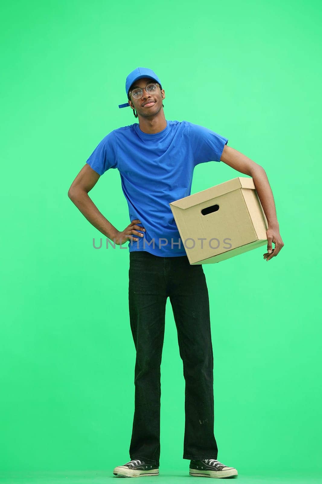 A male deliveryman, on a green background, full-length, with a box by Prosto