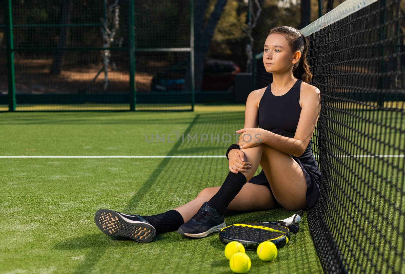 Padel tennis player with racket. Girl athlete with paddle racket on court outdoors. Sport concept. Download a high quality photo for the design of a sports app or web site
