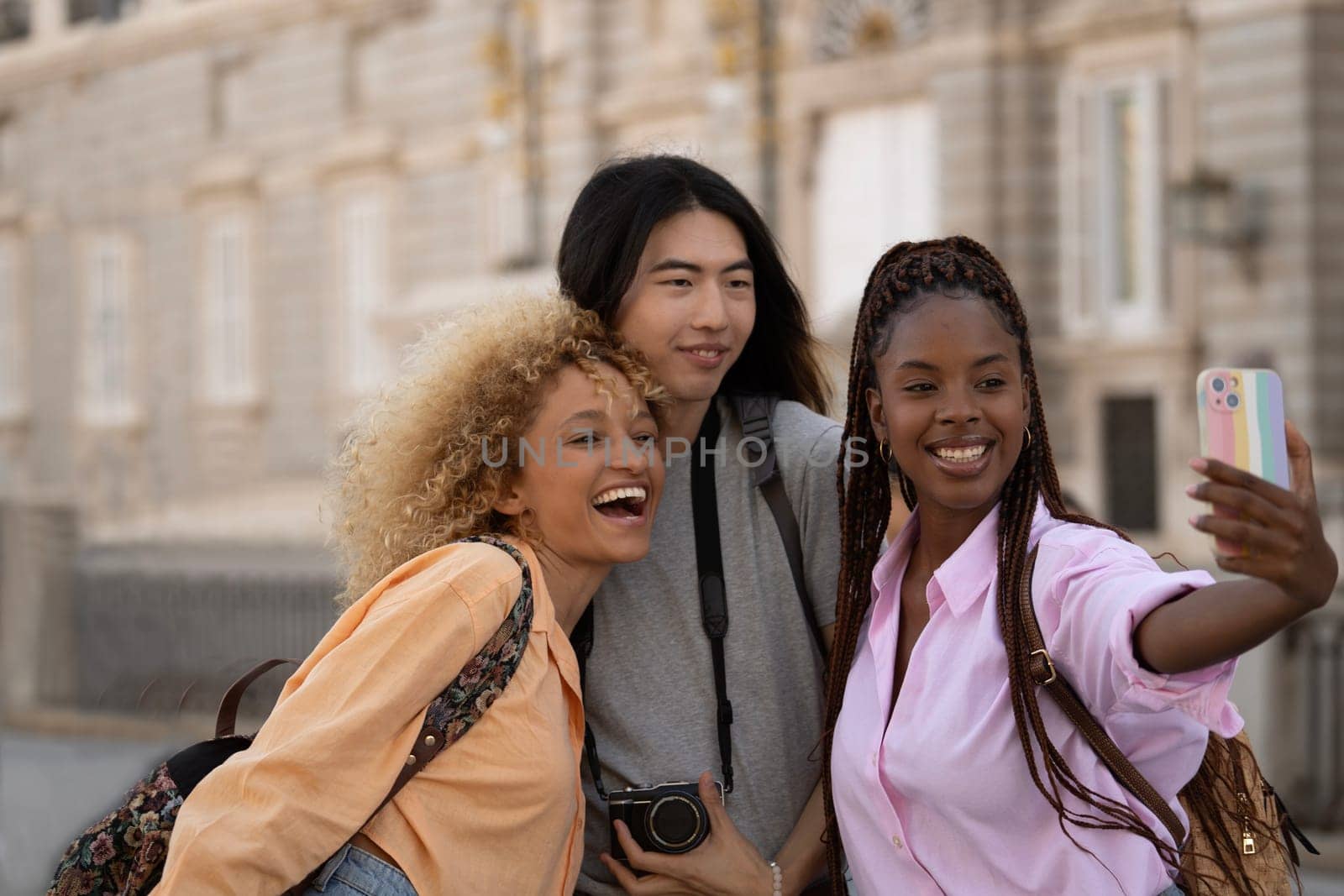 Portrait of multiethnic group of tourists friends taking a selfie in Madrid city.