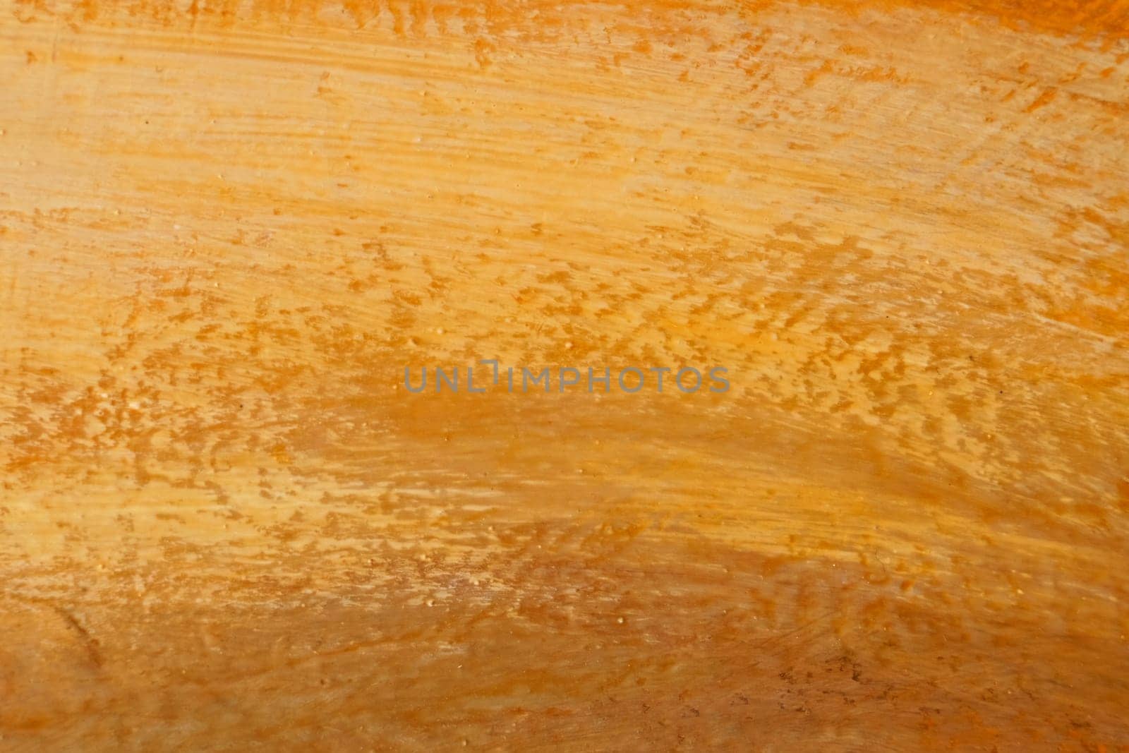 The bright texture of the canvas, painted in orange-yellow-brown colors with shades. Abstract background
