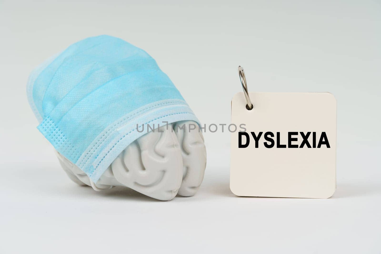 Medical concept. On a white surface next to the brain there is a notepad with the inscription - Dyslexia