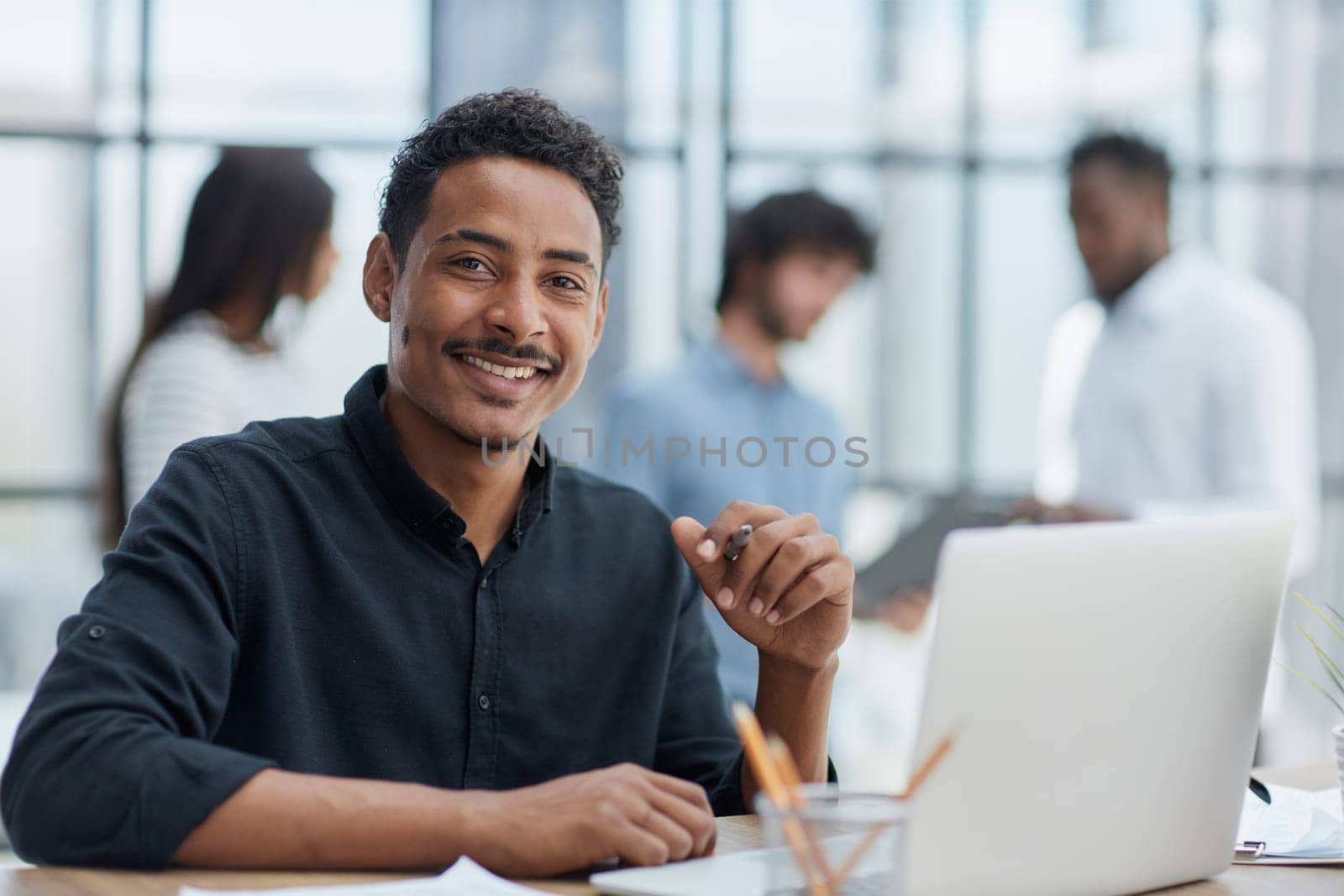 Cheerful businessman working at desk, confident and engaged. by Prosto