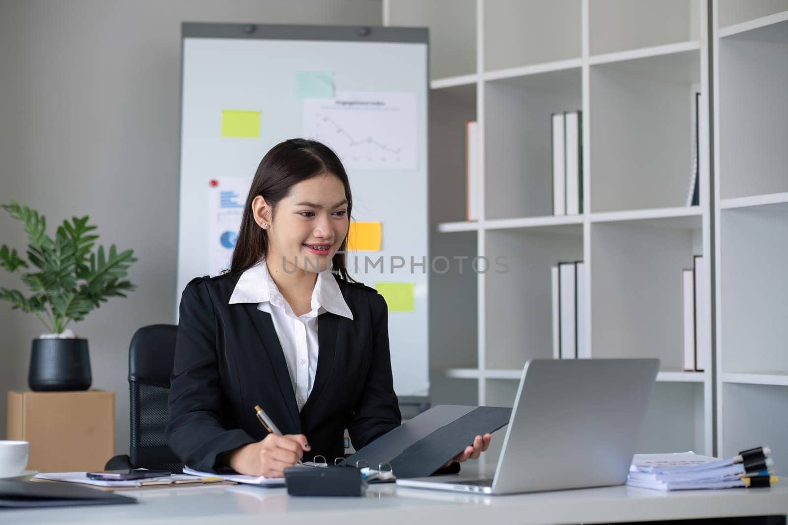 Business documents, business auditor Asian woman is reviewing legal documents, preparing documents or reports for analysis tax accountant documents agreement contract information in office at work by wichayada
