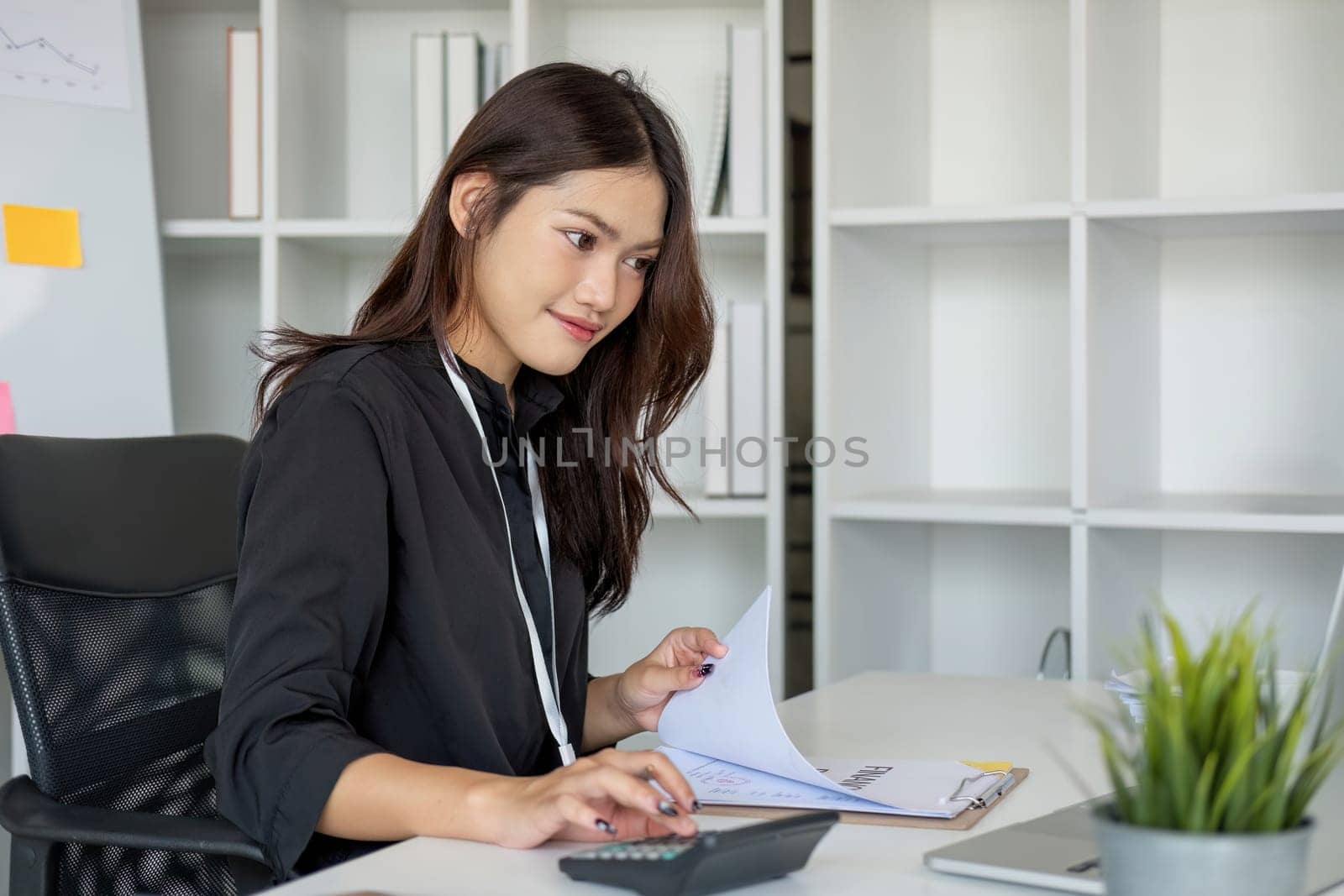 Business woman using calculator and laptop for do math finance on wooden desk in office and business working background, tax, accounting, statistics and analytic research concept.