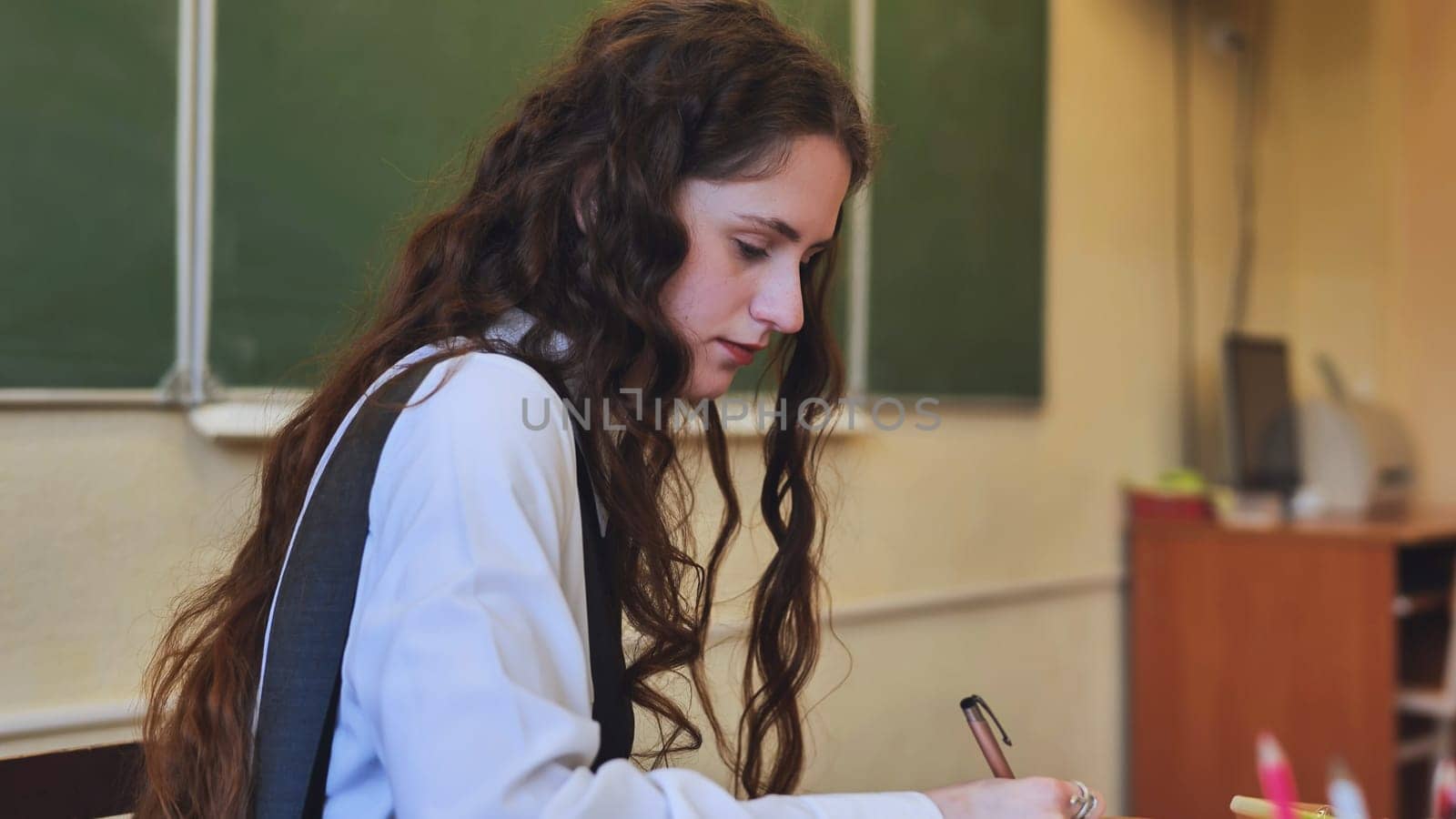 A young female student leads the class in the role of teacher
