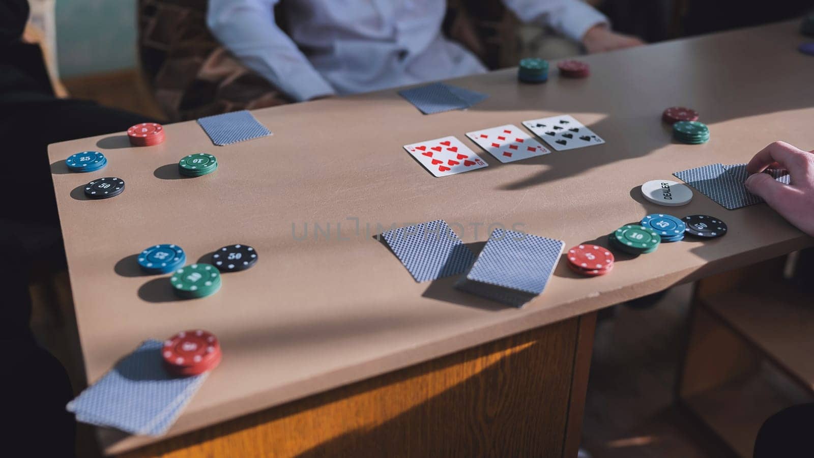 Young guys playing poker at a table. by DovidPro