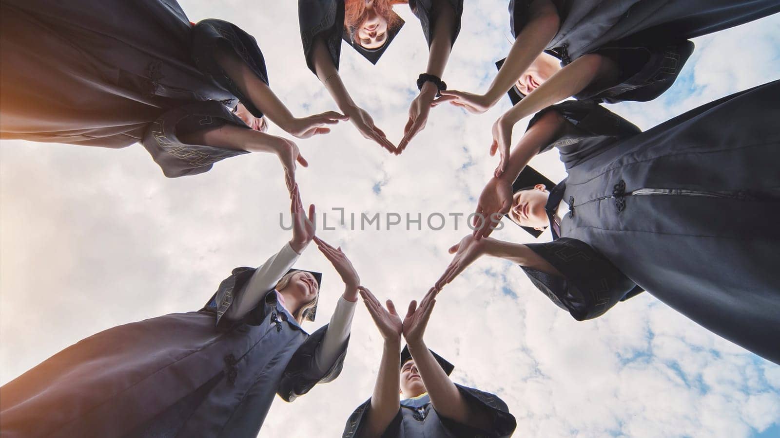 Students graduating from the college make a heart out of their hands. by DovidPro