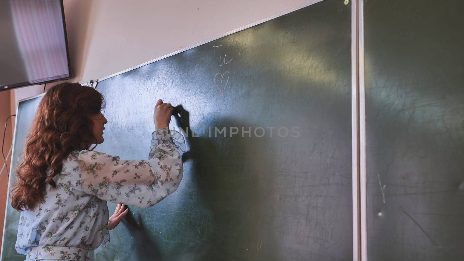 A girl student writes on the green board