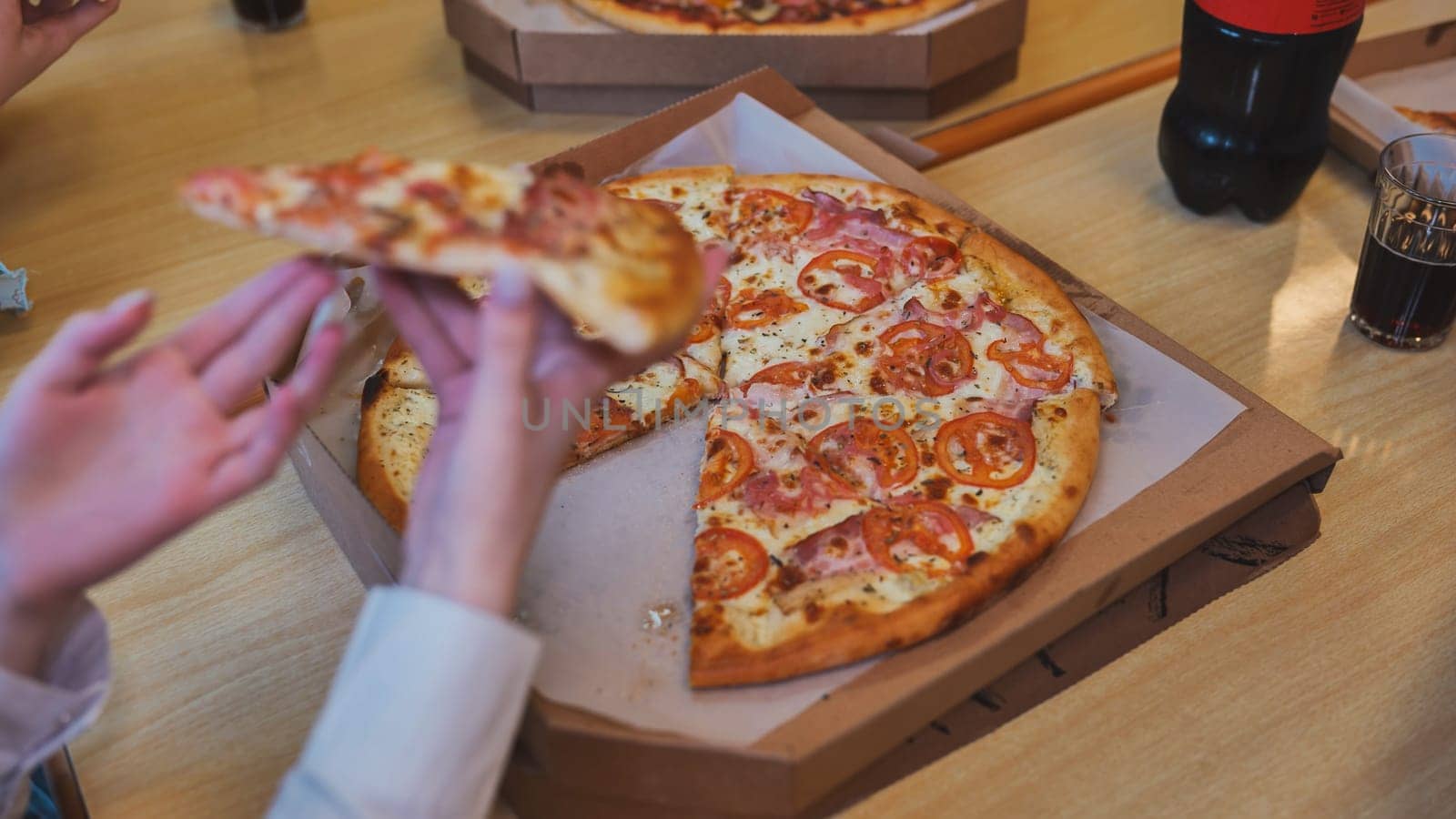 Students take a slice of pizza in the cafeteria. by DovidPro