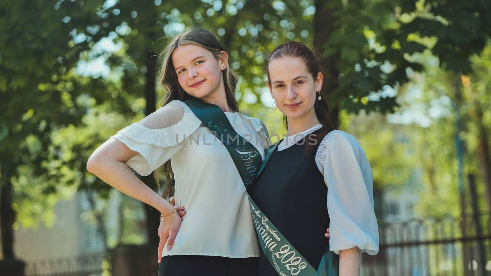 Two Russian schoolgirls graduate posing on a summer day. by DovidPro