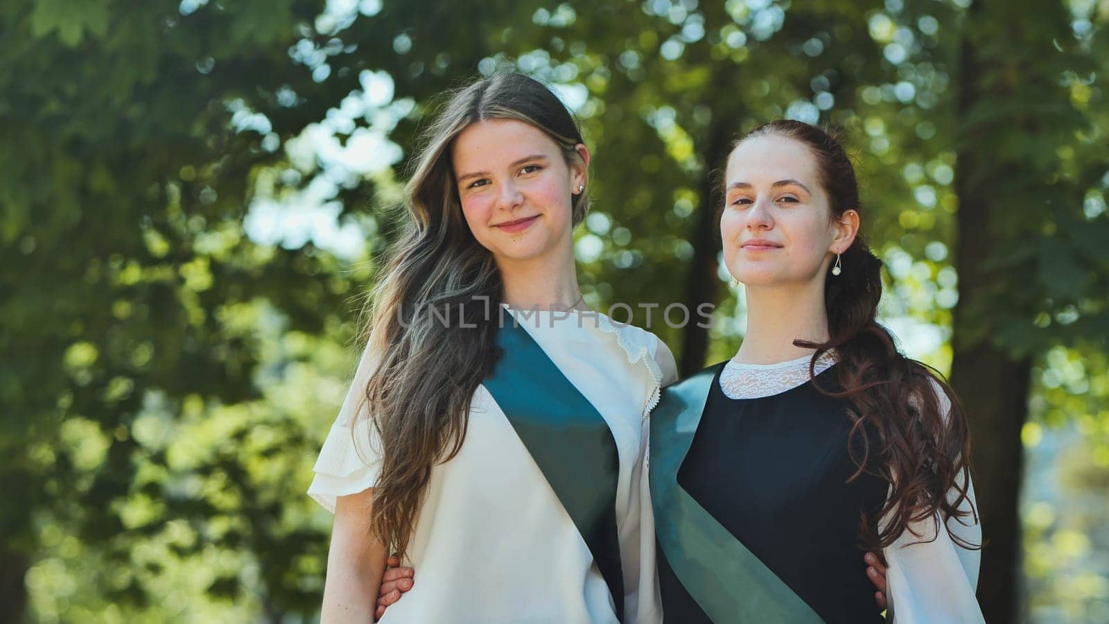 Two Russian schoolgirls graduate posing on a summer day. by DovidPro