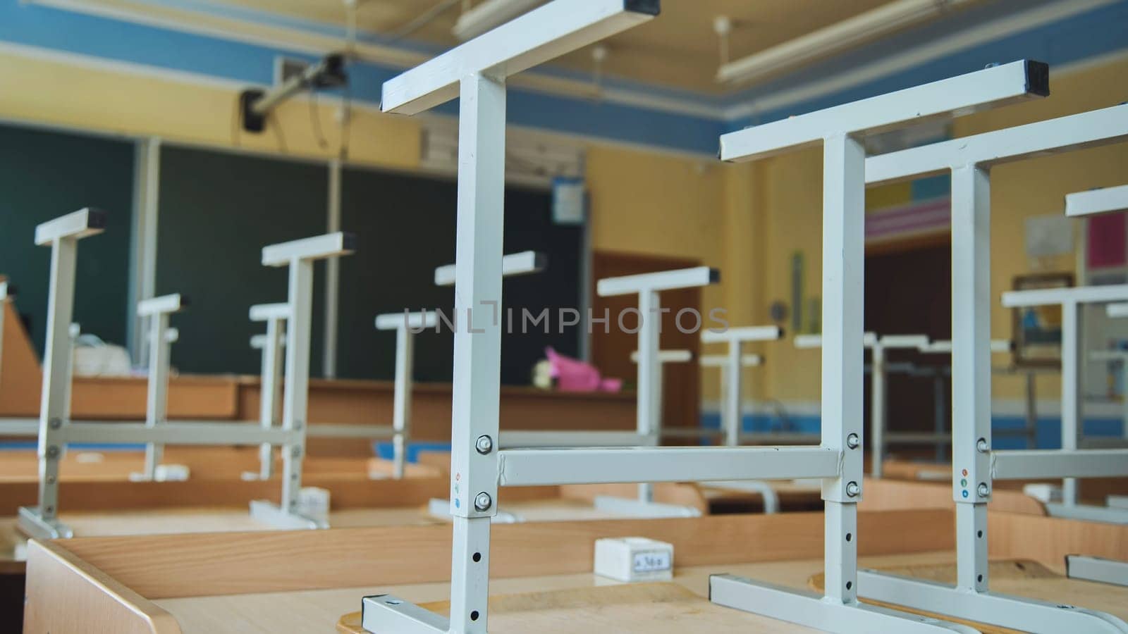 The concept of graduating from high school. Upside-down chairs in an empty classroom at the school. by DovidPro