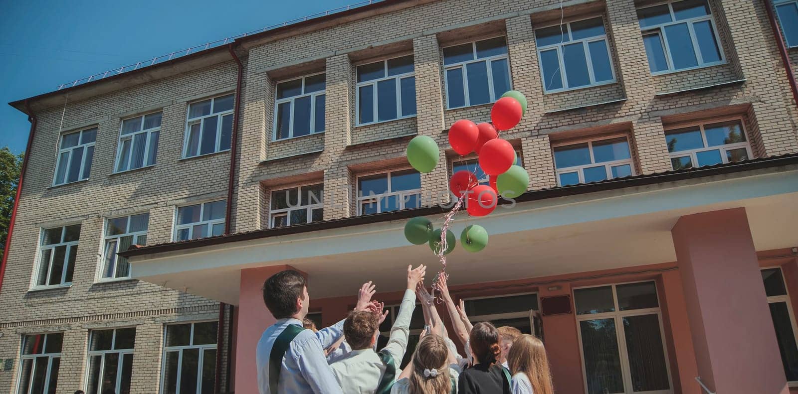 Berezovka, Belarus - May 31, 2023: High school graduates launch balloons into the sky.