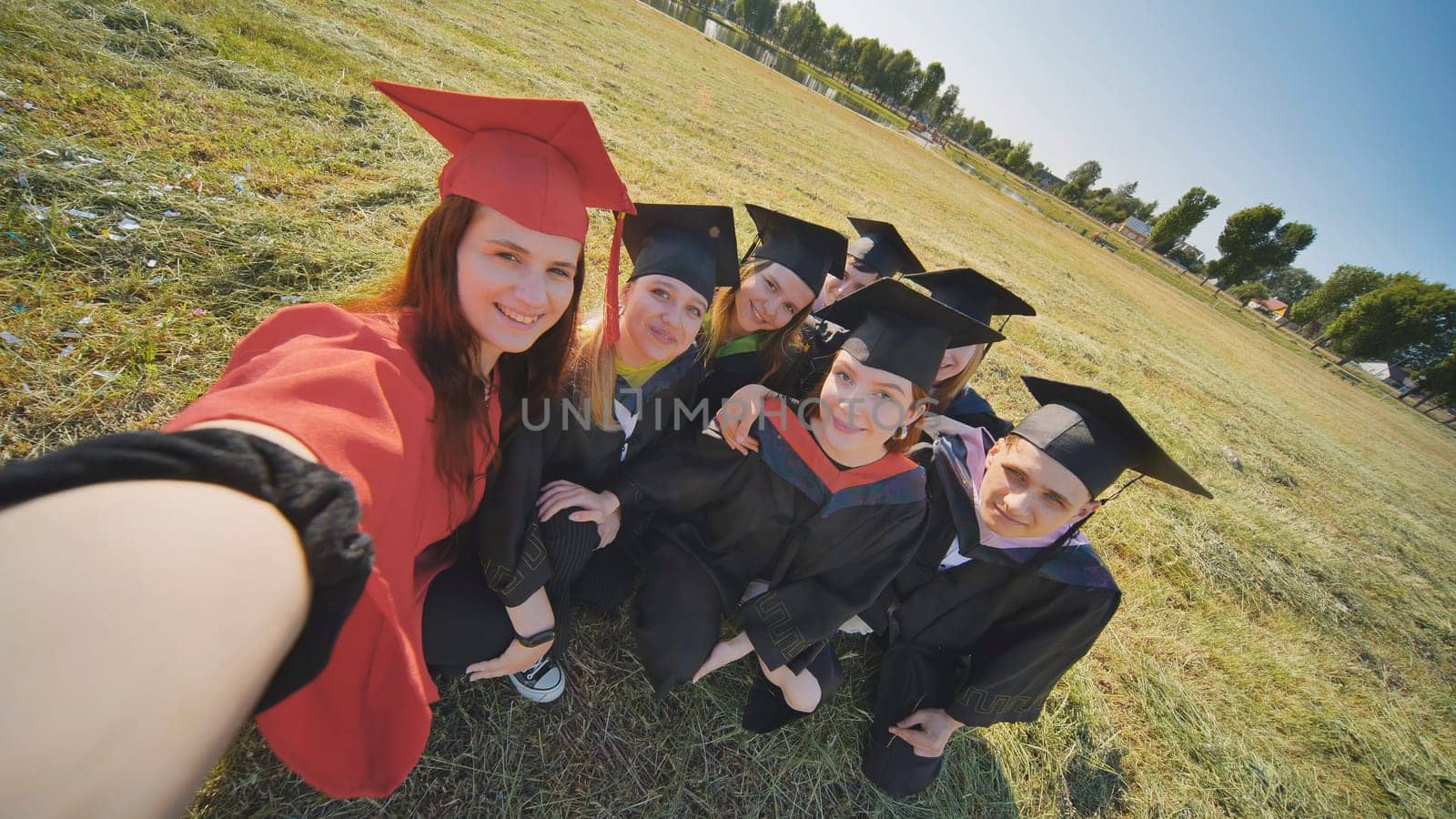 College alumni take selfies in the meadow. by DovidPro