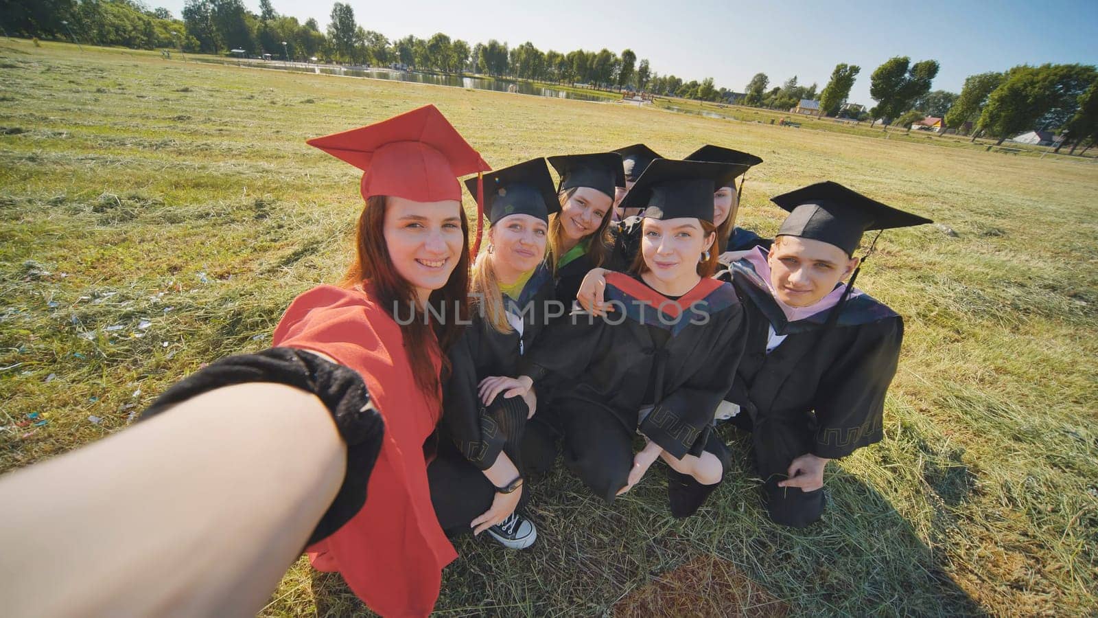 College alumni take selfies in the meadow. by DovidPro