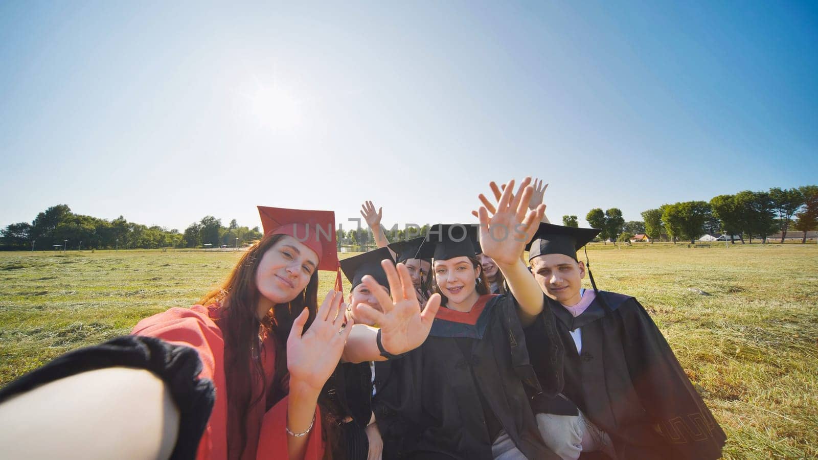 College alumni take selfies in the meadow. by DovidPro