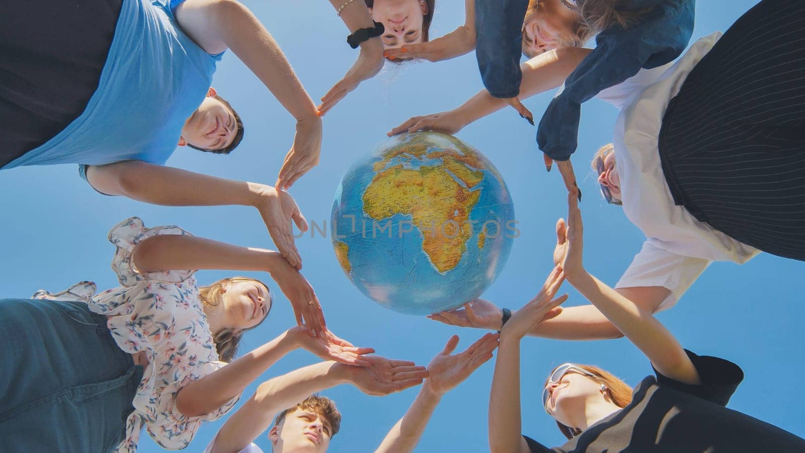 Students make a circle around the globe of the world. The concept of world peace. by DovidPro