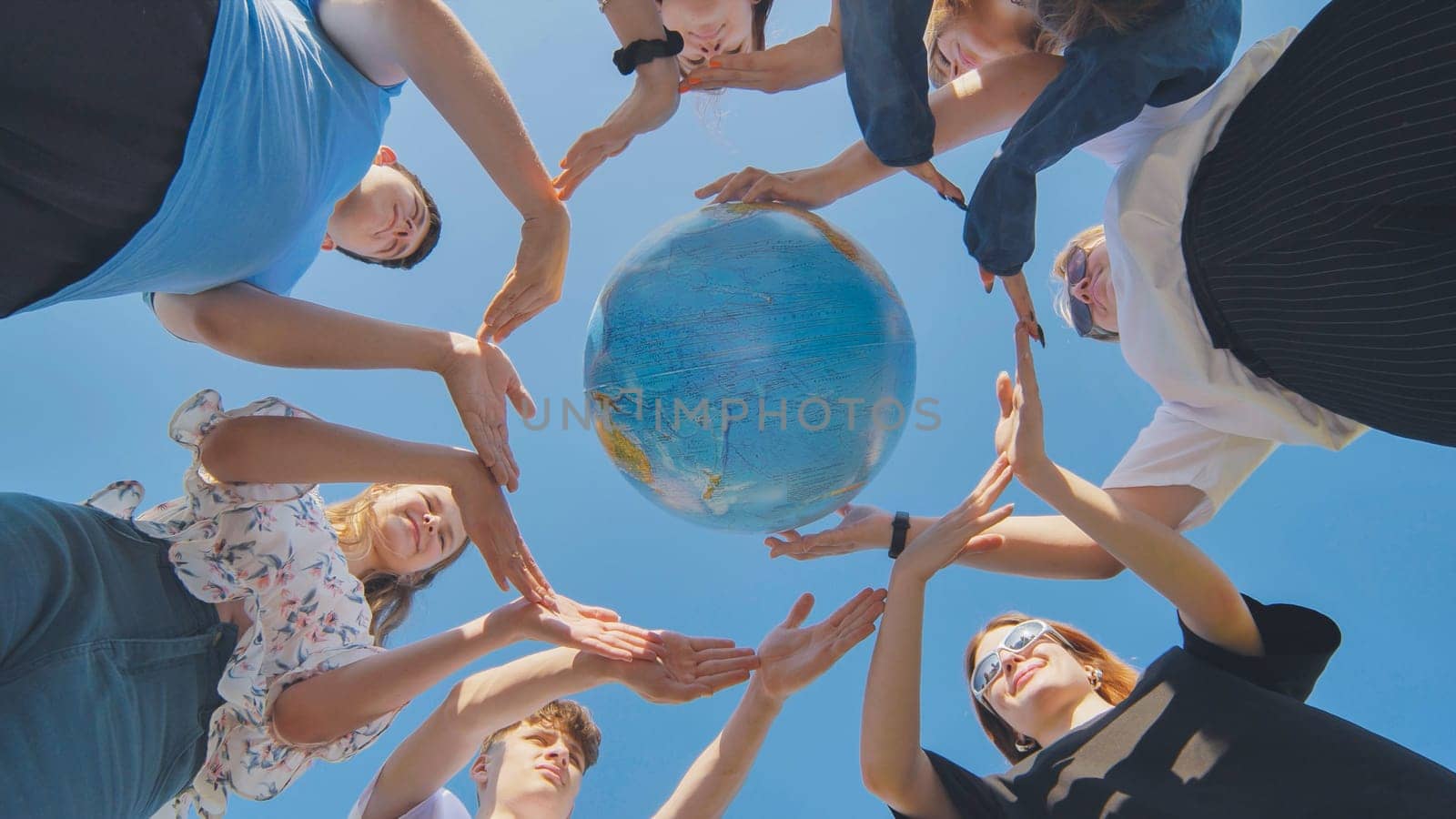 Students make a circle around the globe of the world. The concept of world peace