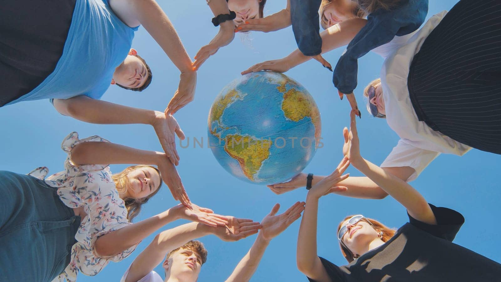 Students make a circle around the globe of the world. The concept of world peace