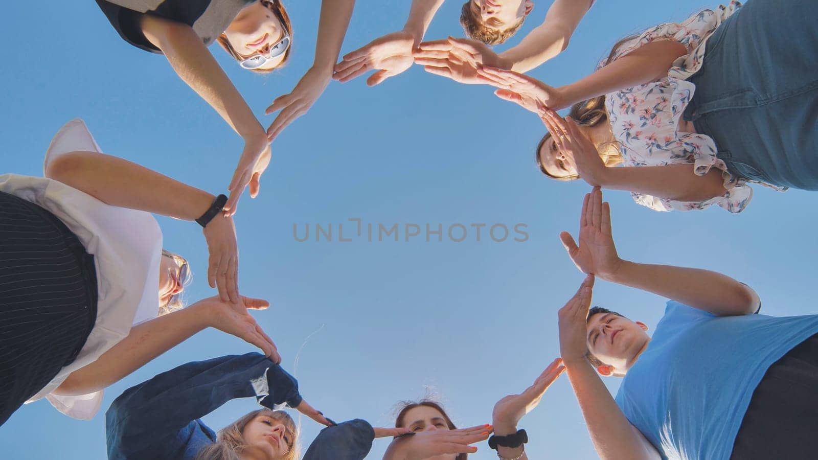 School friends make a big circle with their hands. by DovidPro