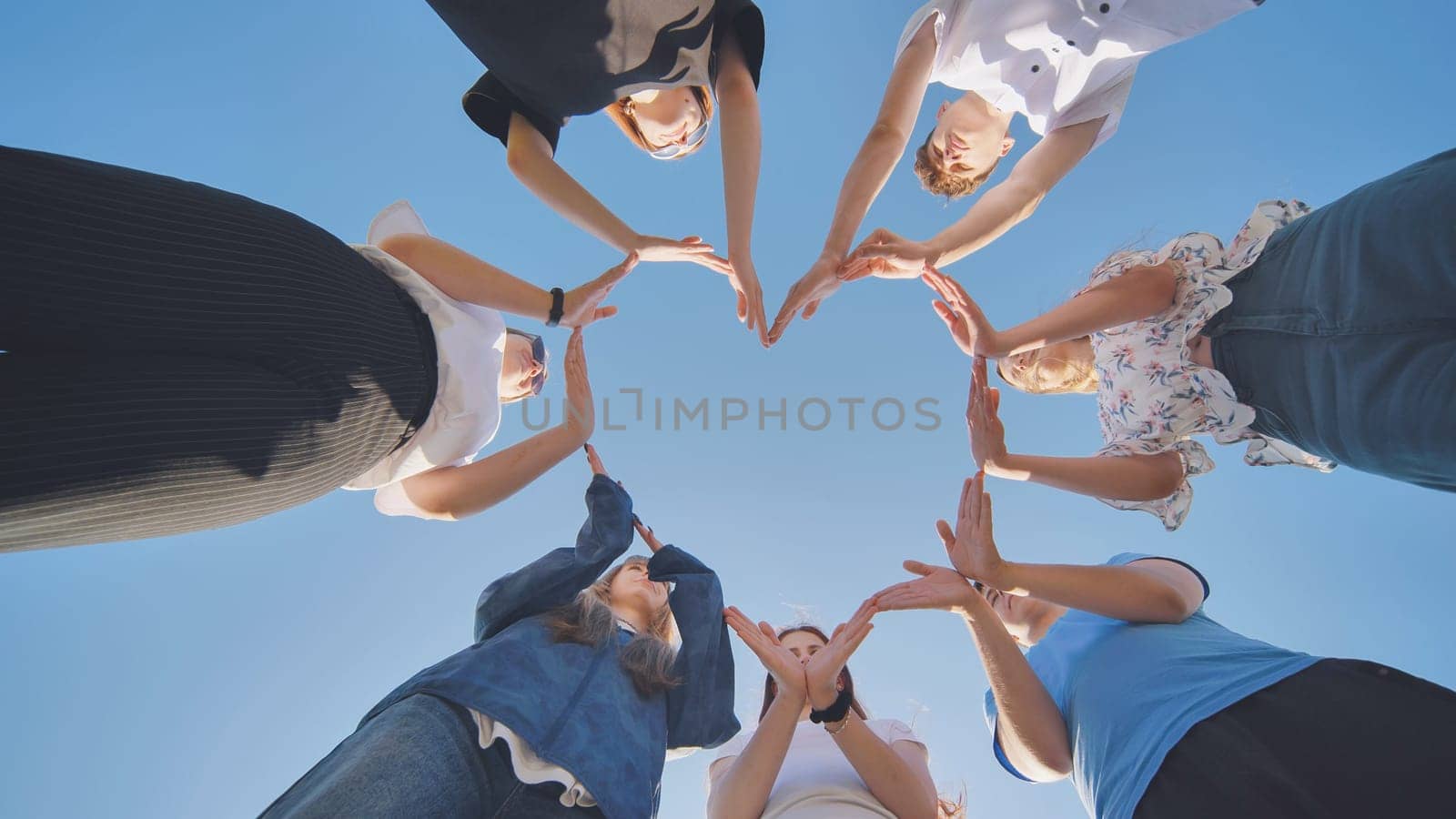 School children make a heart shape from their hands