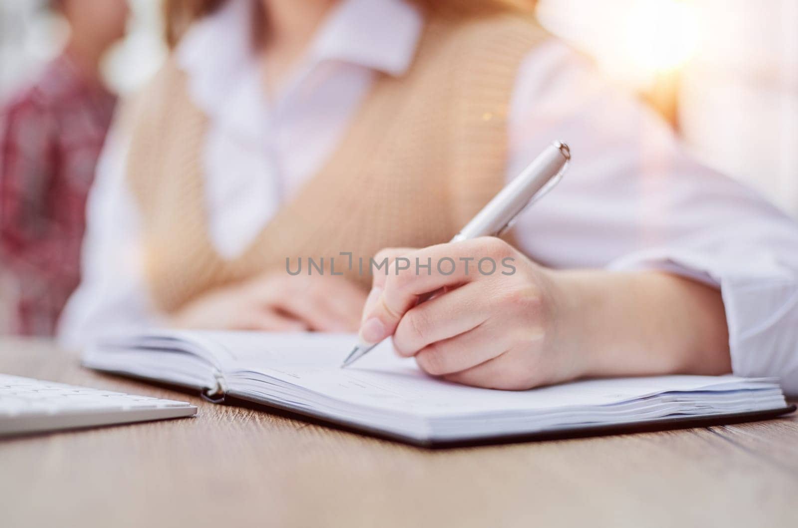 Image beautiful woman writing down notes while sitting at table in office