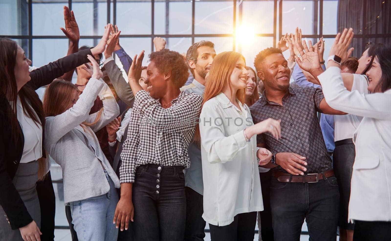 Excited multinational employees celebrating team victory giving high five