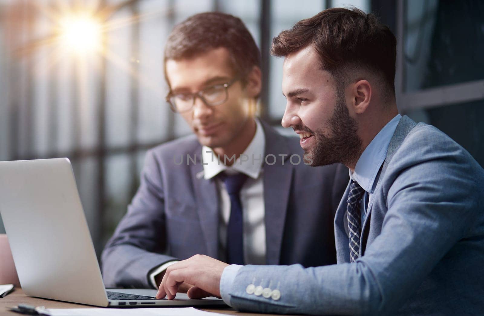Two man colleagues working at the office on a computer