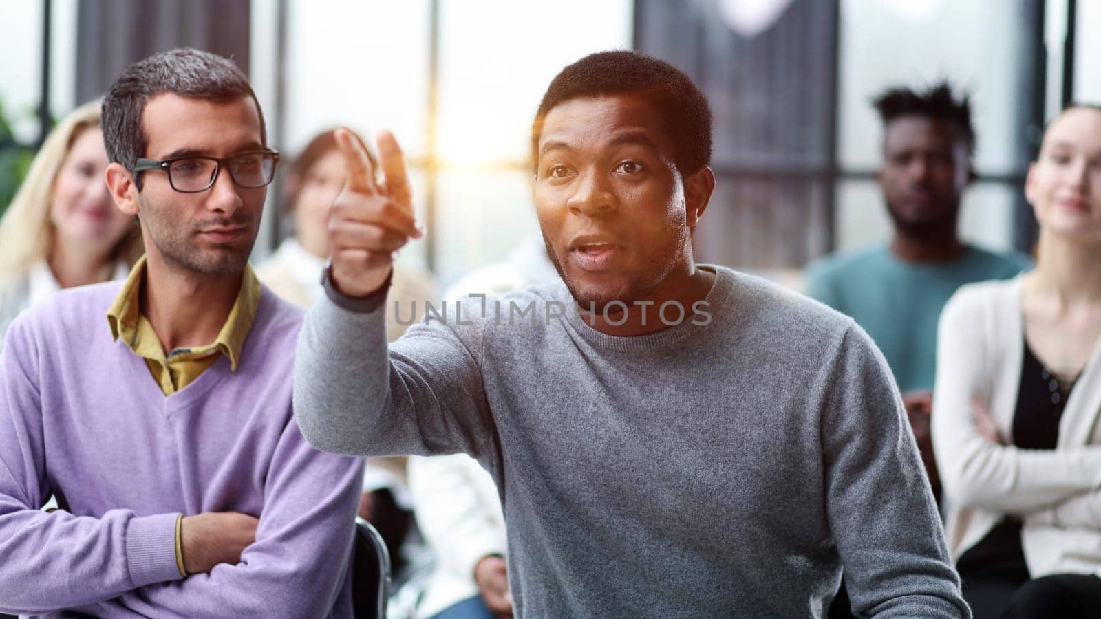 African American business man raise their hand at the conference to answer a question