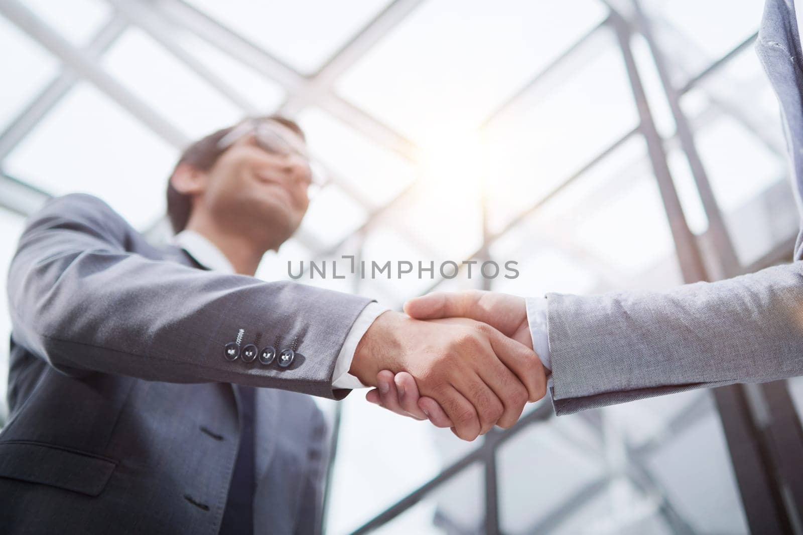 Delighted businessmen shaking hands, greeting acquaintance in the office, by Prosto