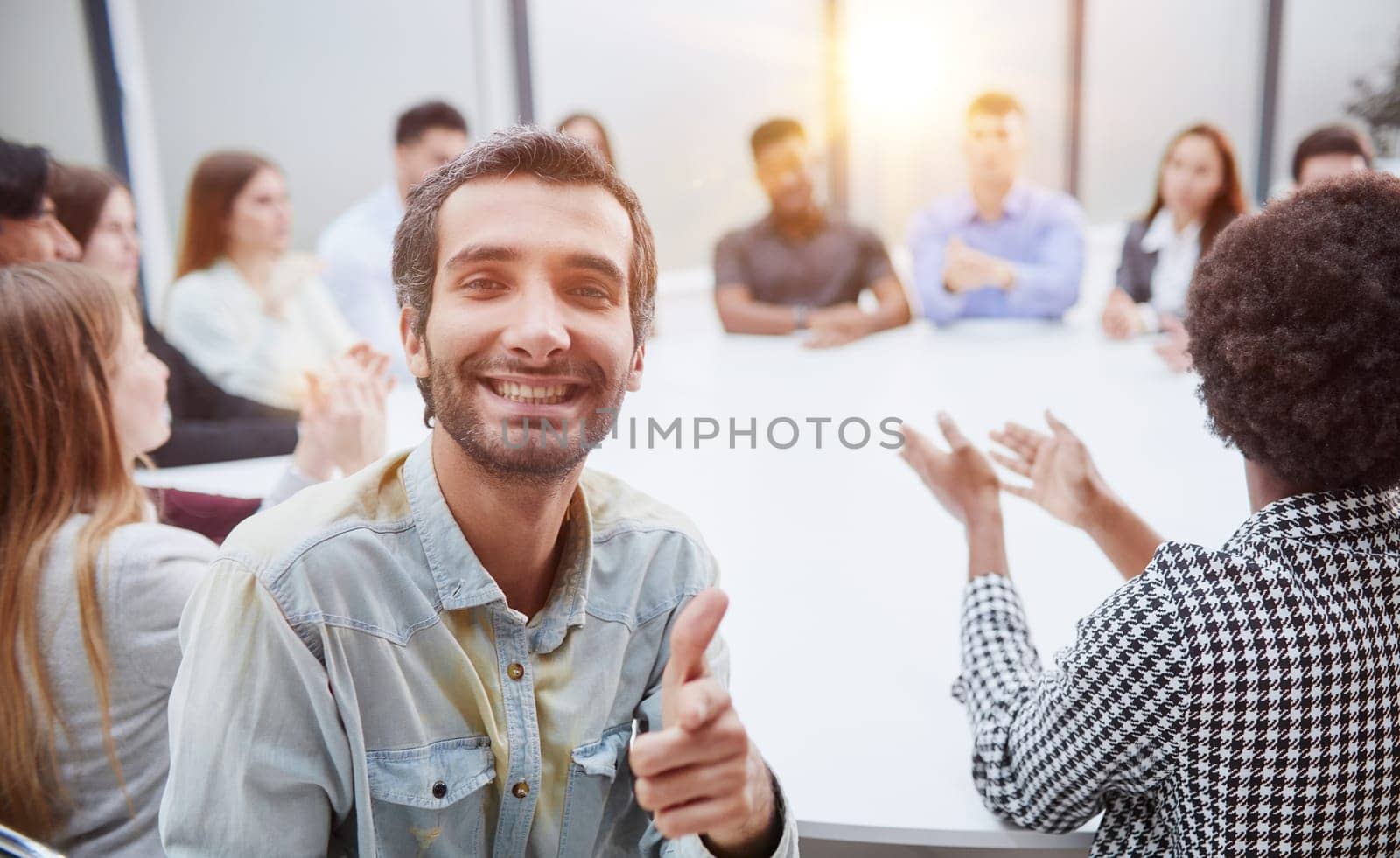 Smiling business group of office workers, executive board members or employees looking at camera sitting at conference table