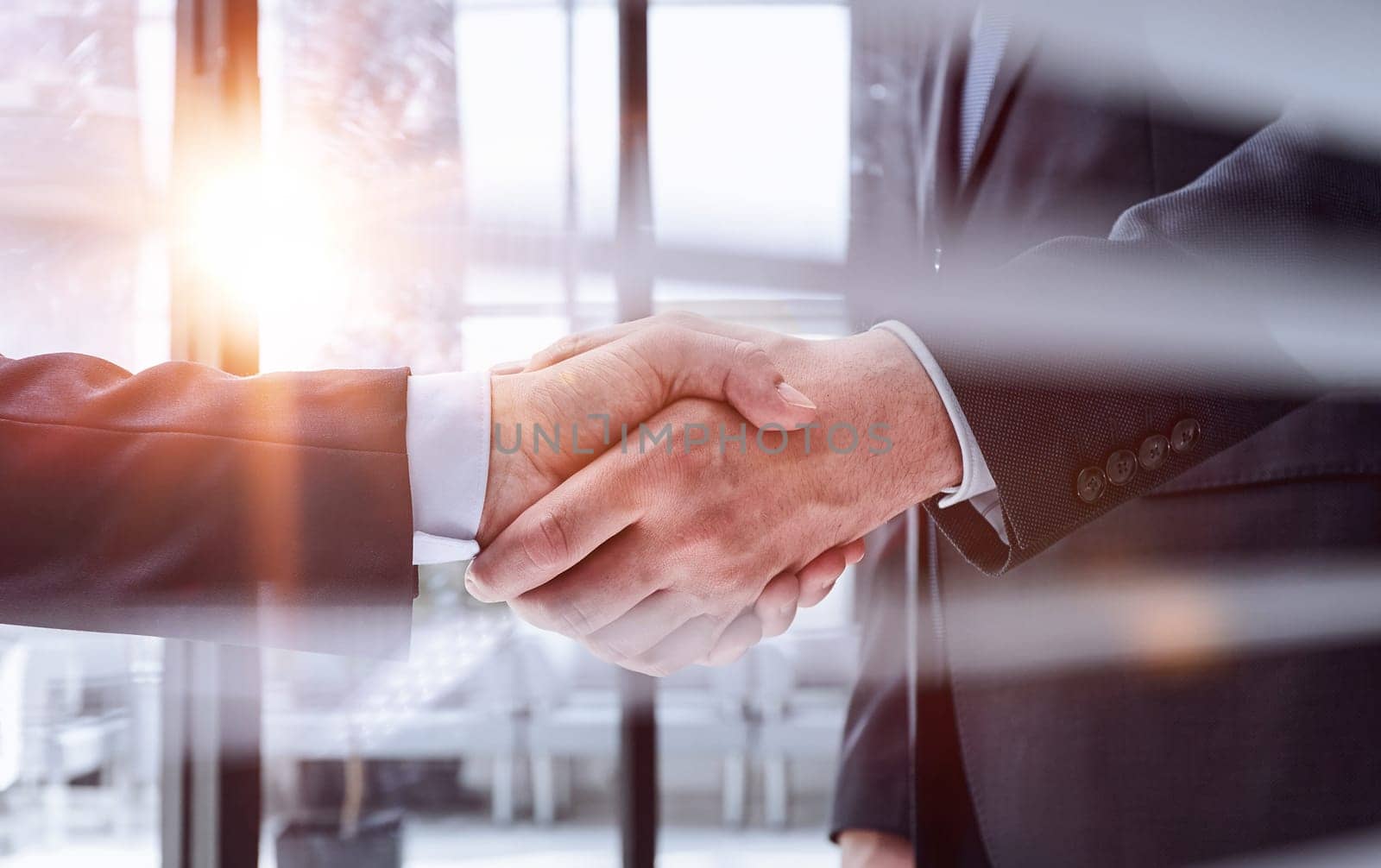executives shaking hands in front of their manager and a colleague by Prosto