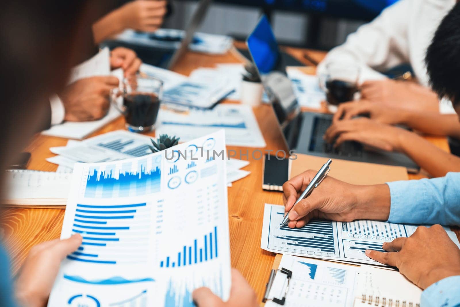 Diverse group of business analyst team analyzing financial data report paper on office table. Chart and graph dashboard by business intelligence analysis for strategic marketing planning Habiliment