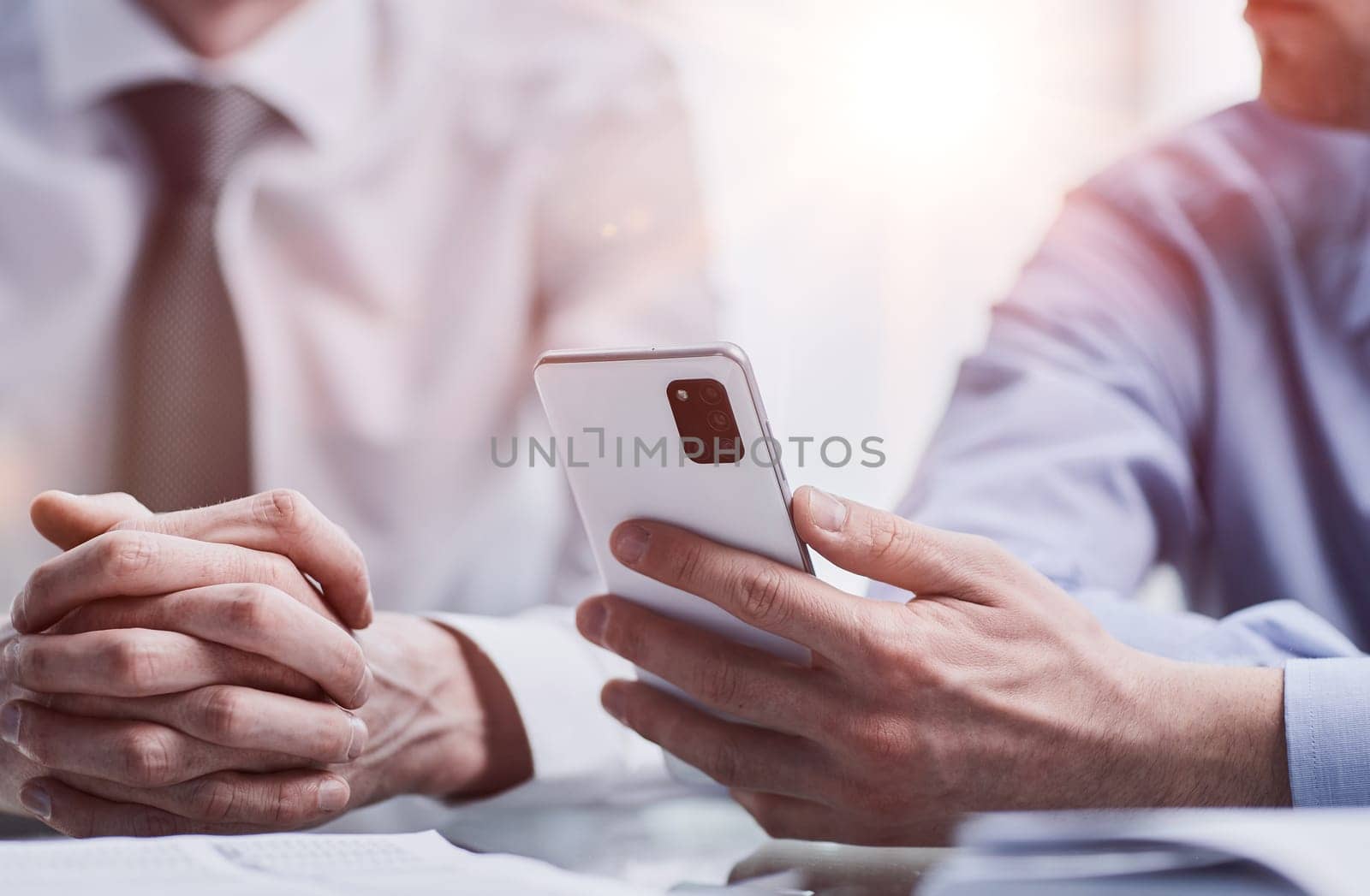 managers read text message on mobile phone in office.