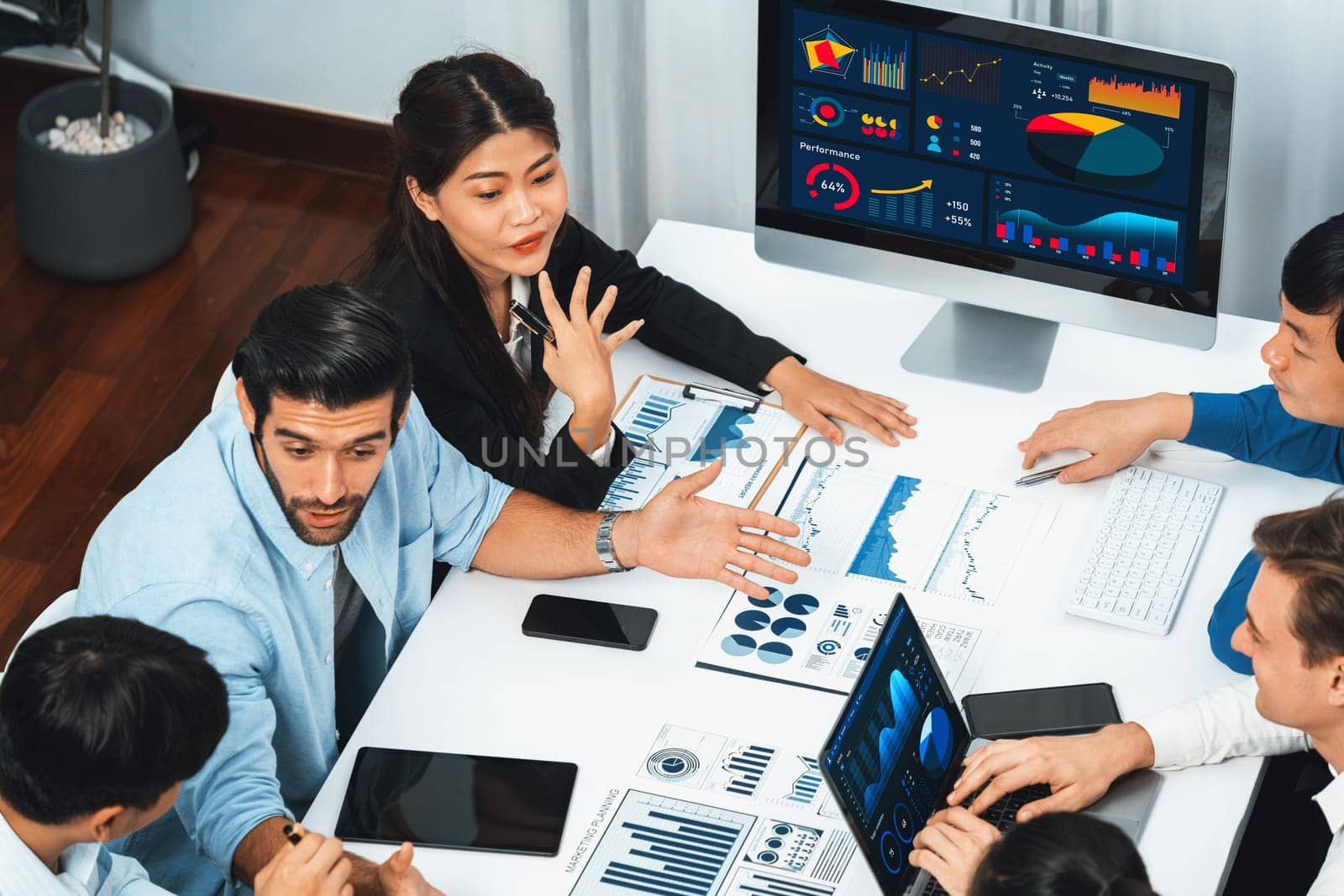 Analyst team utilizing BI Fintech to analyze financial data at table in meeting room. Businesspeople analyzing BI dashboard power on paper for business insight and strategic marketing planning.Prudent