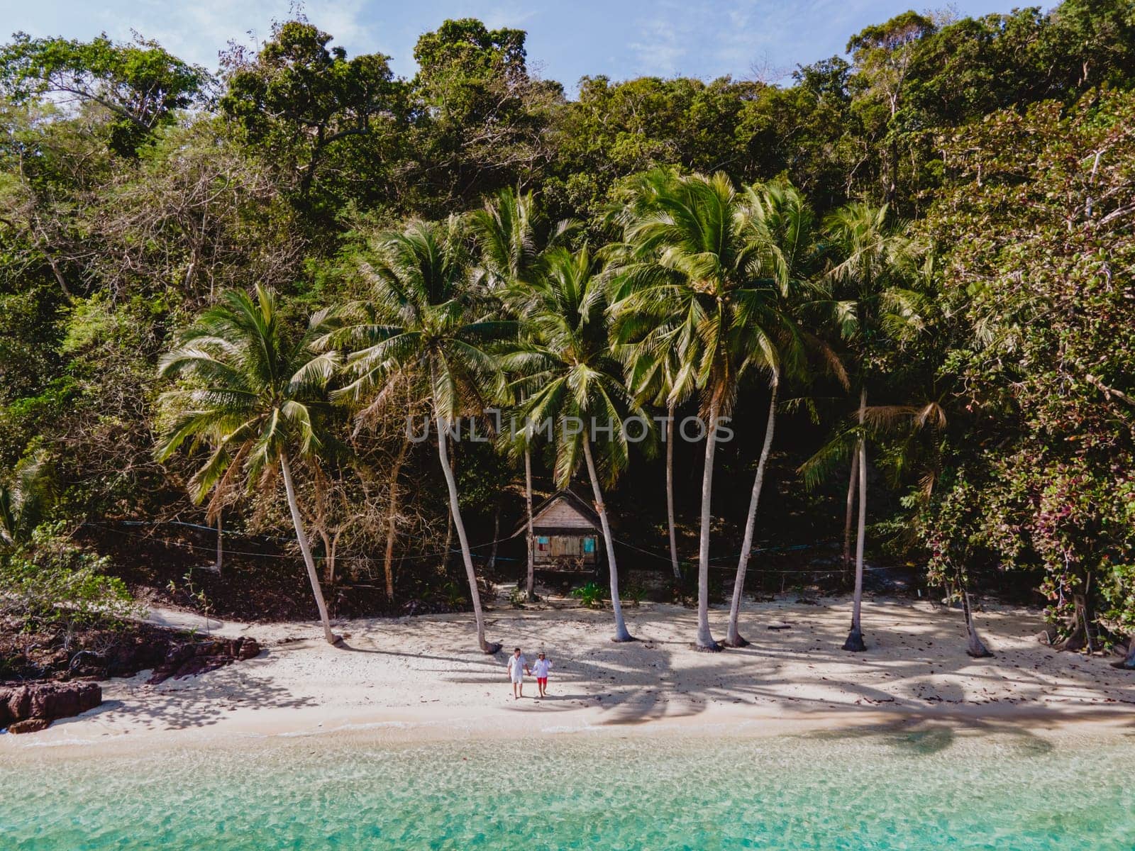 Koh Wai Island Trat Thailand near Koh Chang. wooden bamboo hut bungalow on the beach with palm trees and blue ocean. a young couple of men and woman on a tropical Island in Thailand