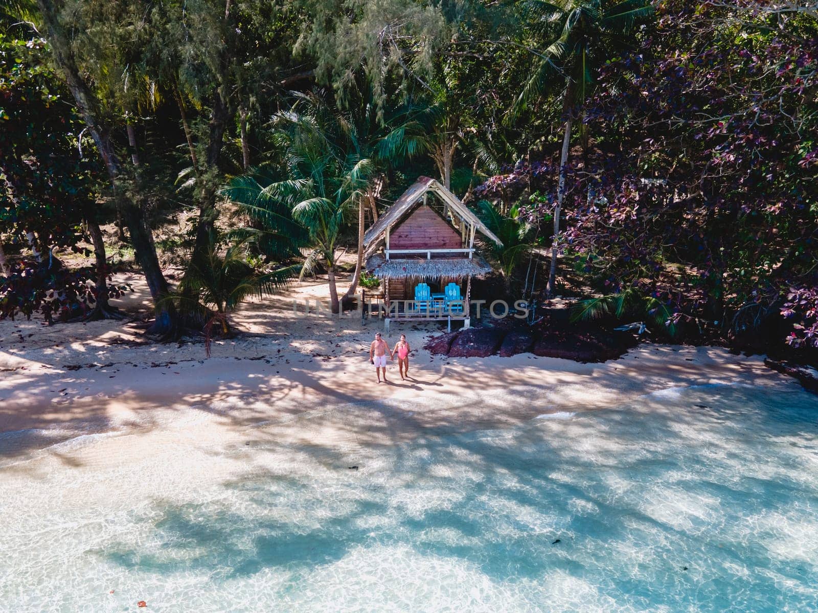 Koh Wai Island Trat Thailand near Koh Chang. wooden bamboo hut bungalow on the beach with a turqouse colored ocean. a young couple of men and woman on a tropical Island in Thailand