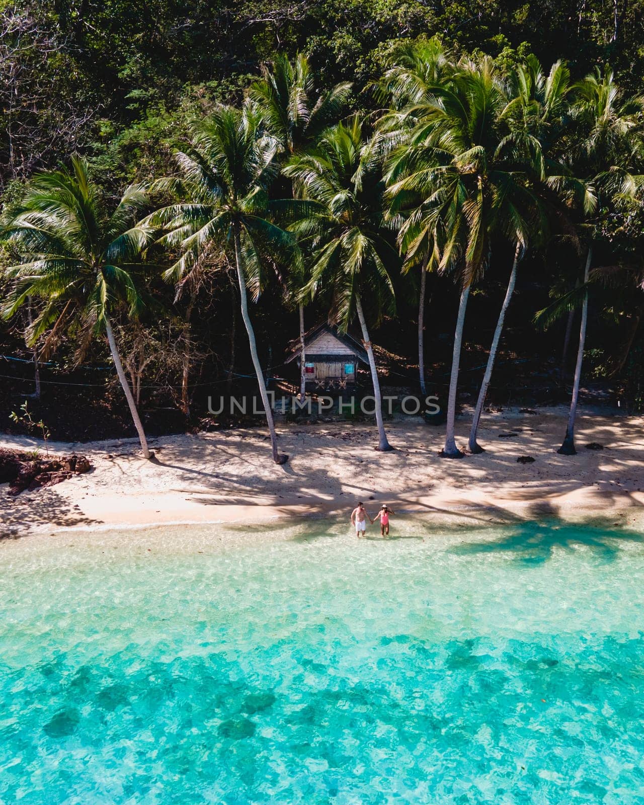 wooden bamboo hut bungalow on the beach with a turqouse colored ocean. a young couple of men and woman on a tropical Island in Thailand on vacation, Koh Wai Island Trat Thailand