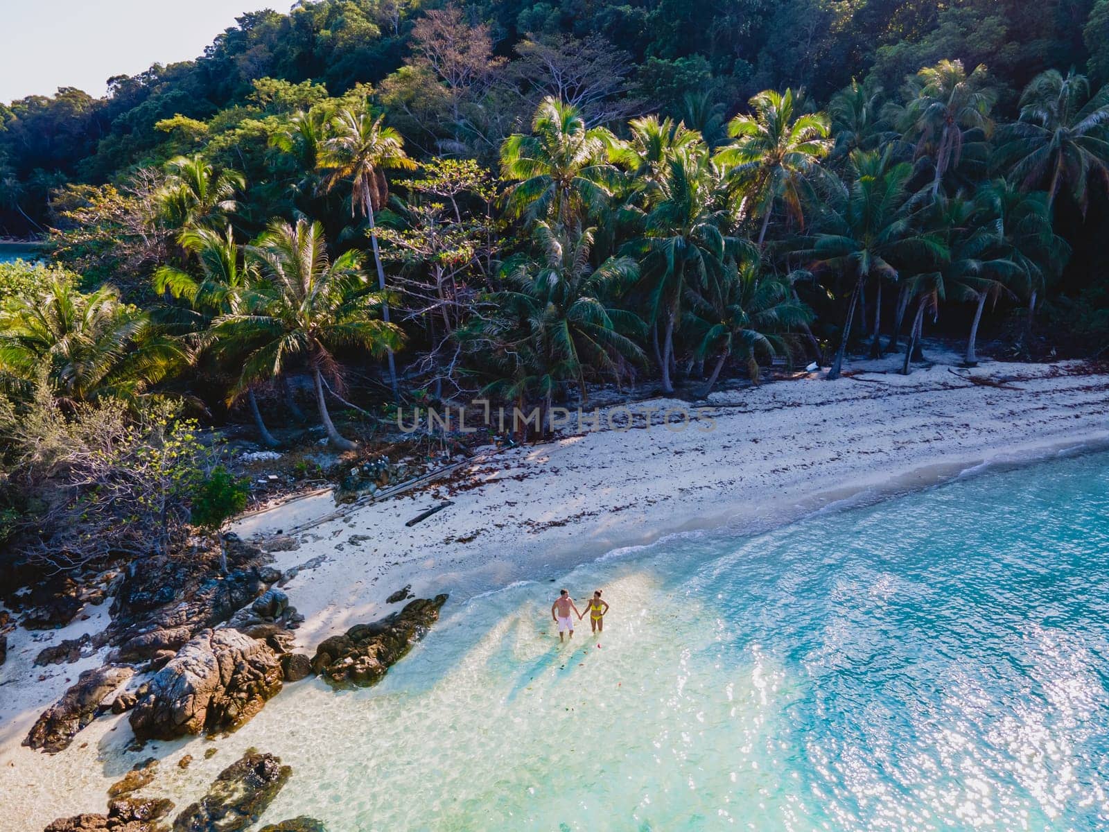 Drone aerial view at Koh Wai Island Trat Thailand. a young couple of men and women on a tropical beach during a luxury vacation in Thailand