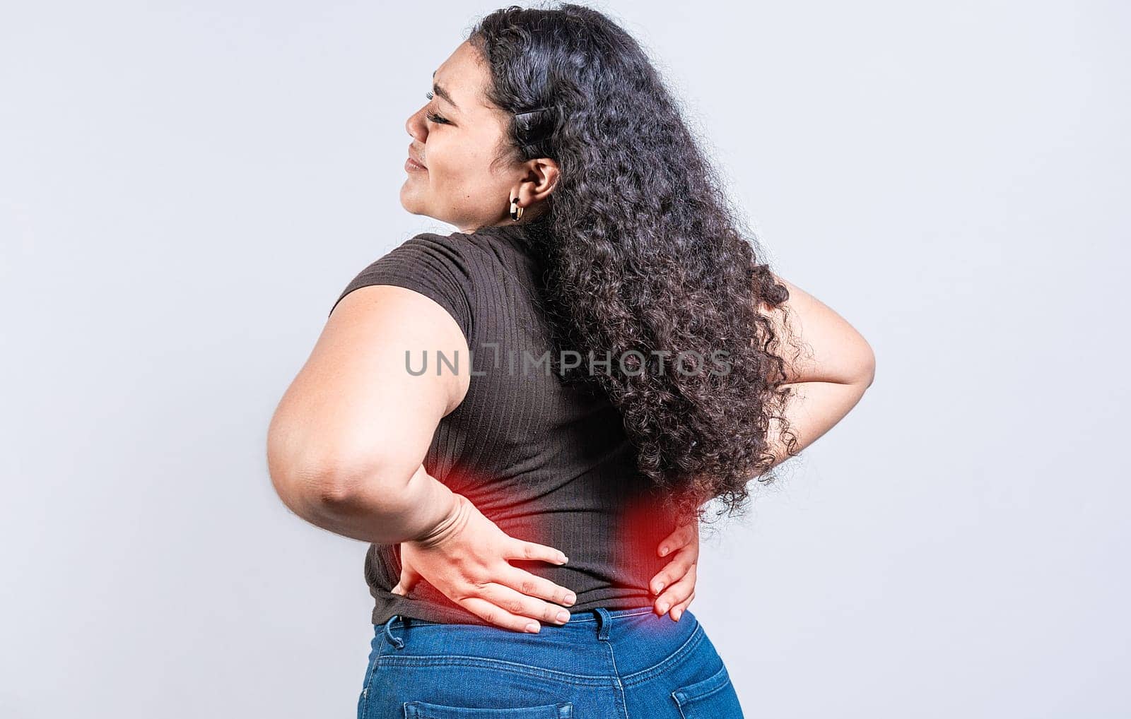 Woman with back pain on isolated background. lumbar problems concept. People with spine problems, A sore girl with back pain