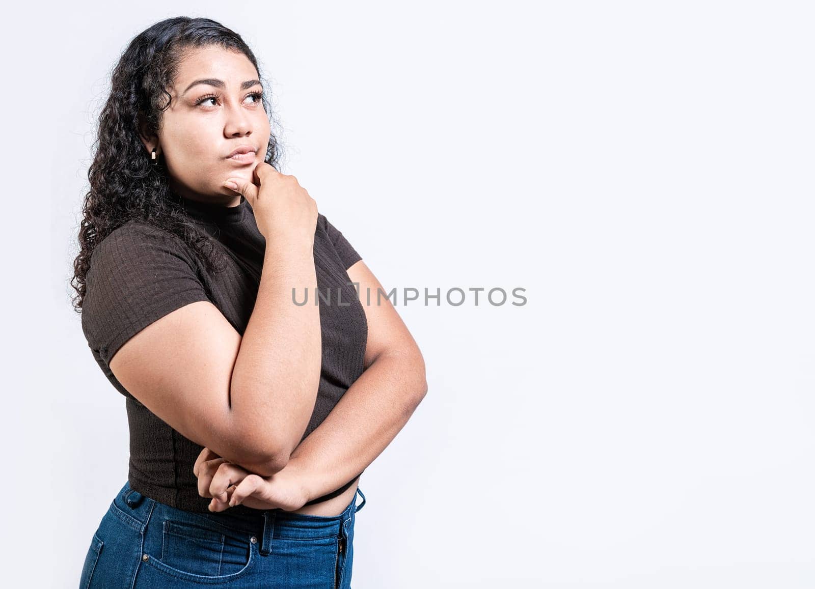 Thoughtful people with hand on chin. Latin girl wondering with hand on chin isolated by isaiphoto