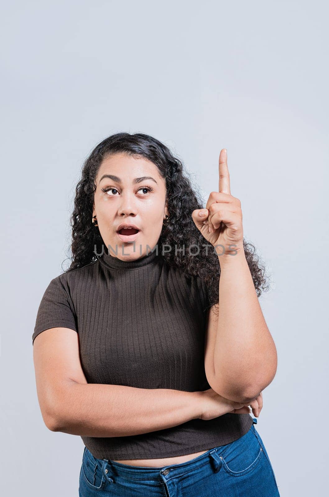 Beautiful latin girl amazed pointing up isolated. Young woman with an idea raising finger isolated by isaiphoto